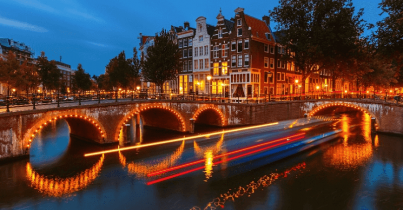Canal iluminando à noite em Amsterdã